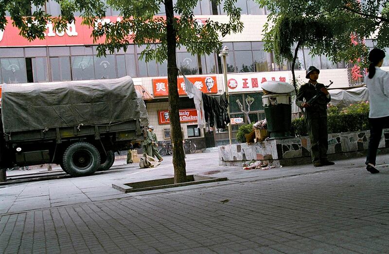 天安门镇压行动之后的六月十日,一名解放军士兵在当时北京唯一的西式快餐店前端枪警戒。(美联社资料图片)