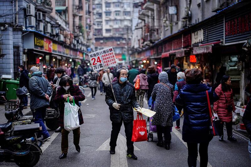 2020年12月7日,湖北省武汉市,新冠病毒爆发近一年后,一名男子在街上推销房子。(路透社)