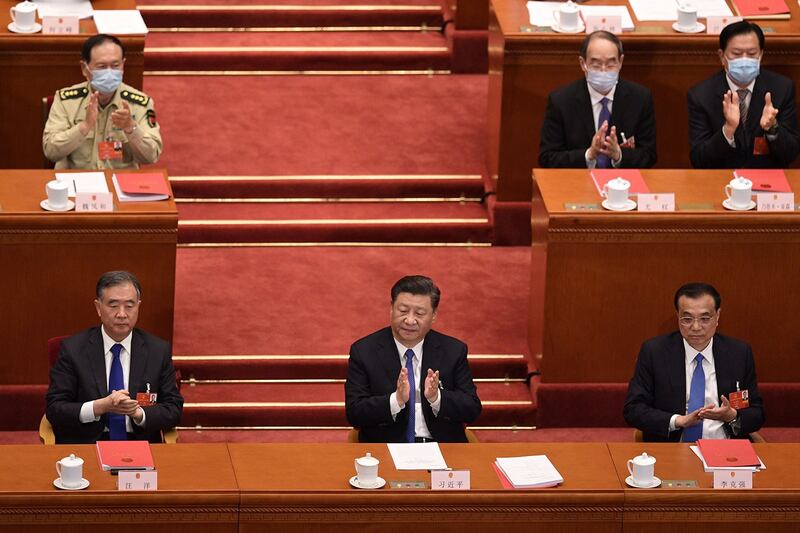 2020年5月28日,在北京人民大会堂举行的全国人民代表大会,习近平(中),李克强(右)和汪洋(左)对起草香港安全法的提案进行投票后。(法新社)